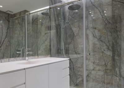Reforma Piso - Baño con mampara y pared de mármol